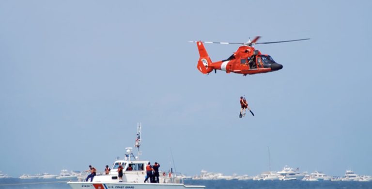 Coast Guard being air lifted out of the water