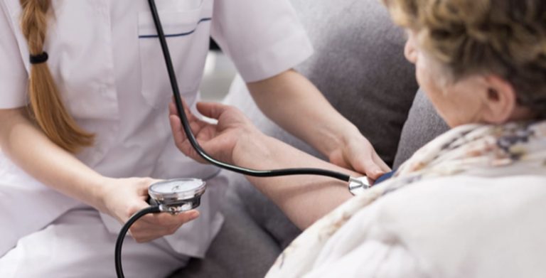 Nurse taking a blood pressure reading from a patient