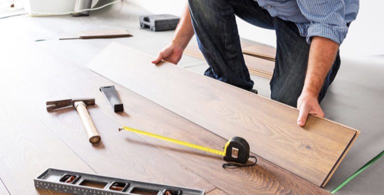 Worker installing wood flooring in a home