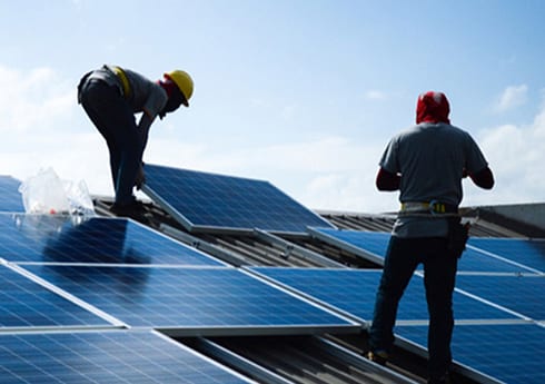 alternative-_use_case Workers installing solar panels on a roof
